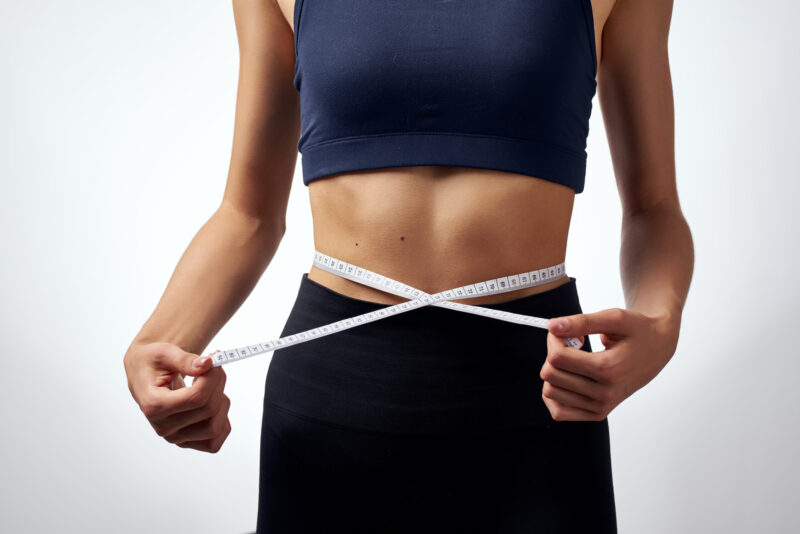 stubborn belly fat, woman measuring waist