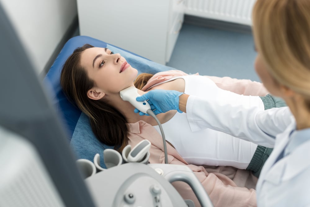 woman laying down and getting thyroid treatment