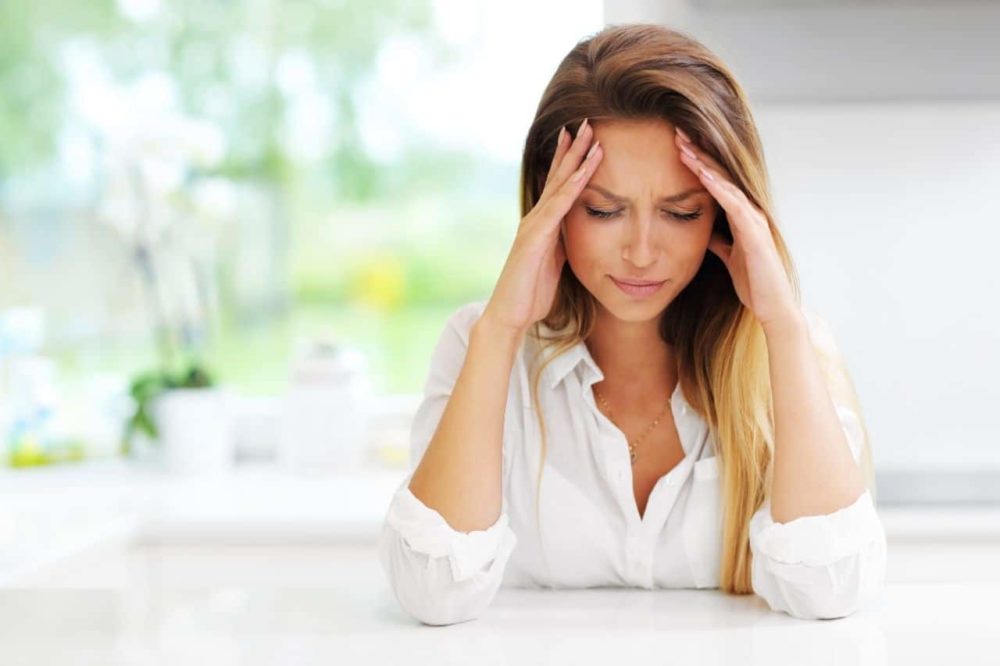 Woman visible worried and in pain possibly experiencing symptoms of hormone imbalance