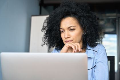 young-serious-concerned-african-american-businesswoman-sitting-at-desk-looking-laptop-computer-in-contemporary-corporation-office-business-technologies-concept-close-up-portrait