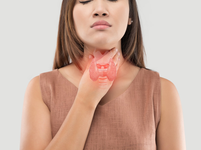 woman holding her throat with a superimposed thyroid gland to illustrate symptoms of thyroid problems in women