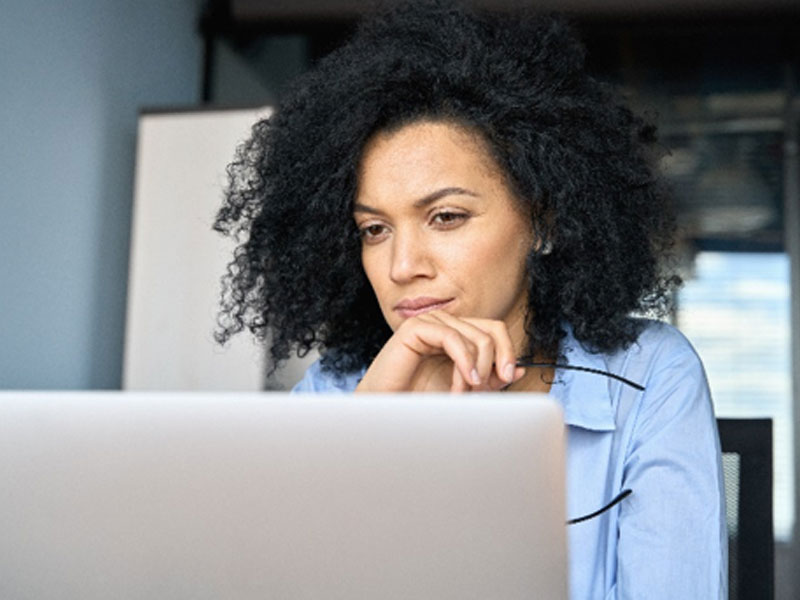 Female researching early menopause on the internet on her laptop