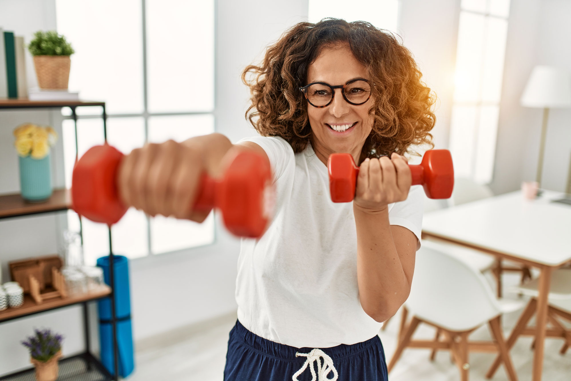 middle aged women on hormone therapy builds muscle with hand weights
