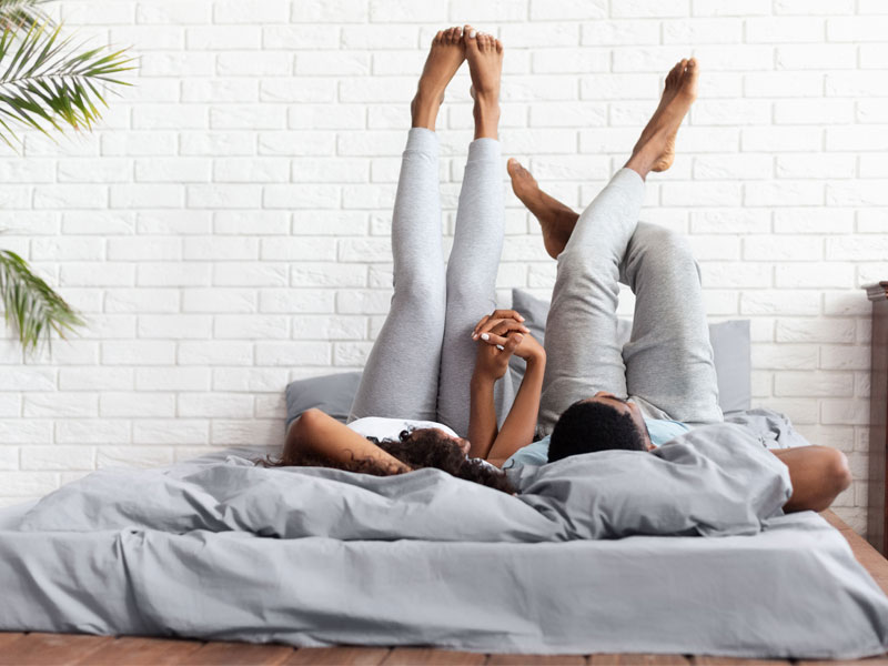 happy couple with legs in the air on the bed to illustrate BHRT for women when sexual desire is at stake
