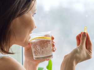 woman taking pill to illustrate peptide therapy