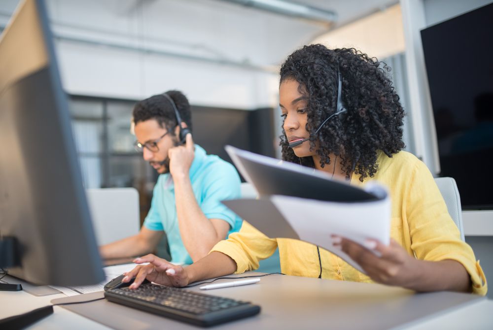 Call center agents sitting at a desk answering phone calls