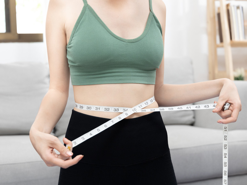 woman with tape round waist to illustrate weight loss medication
