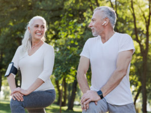 active smiling senior couple wearing activity monitoring device