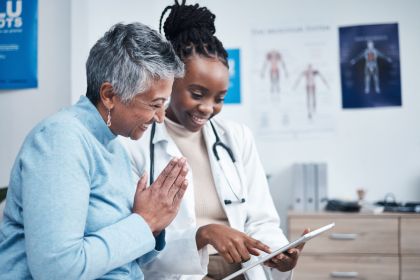 Black woman, doctor and senior patient with tablet, results and happy for health clearance, advice or report. African medic, mobile touchscreen and healthcare with smile, tech and support in hospital