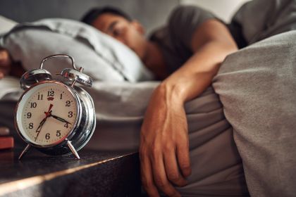 alarm-clock-relax-and-man-sleeping-in-the-bed-of-his-modern-apartment-in-the-morning-lazy-resting-and-closeup-of-a-timer-bell-with-a-male-person-taking-a-nap-and-dreaming-in-bedroom-at-his-home