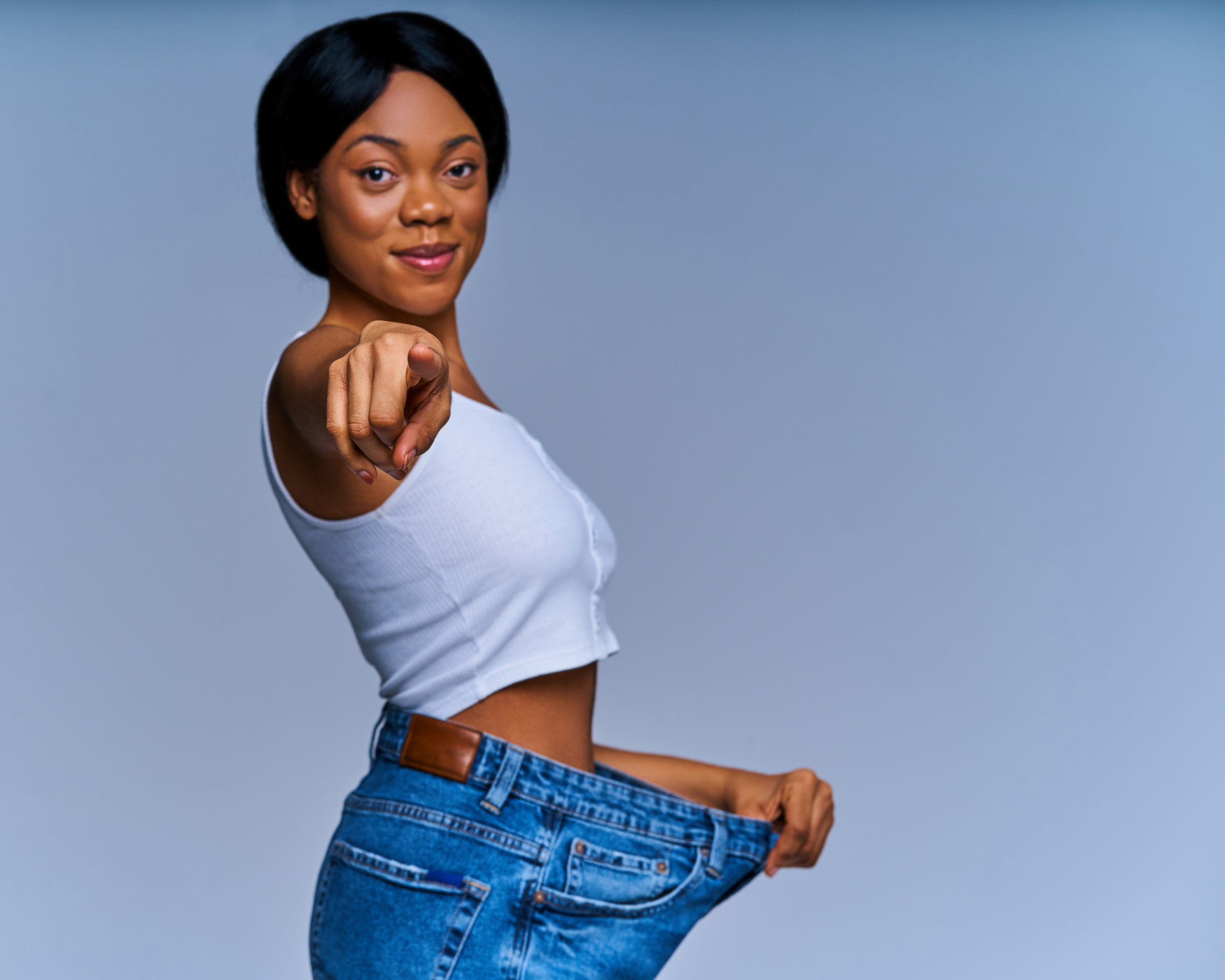 Licensed Save to Library Preview Crop Find Similar Expand Image FILE #: 358938059 Happy woman in white top in oversize jeans smiles and shows victory gesture. Diet concept