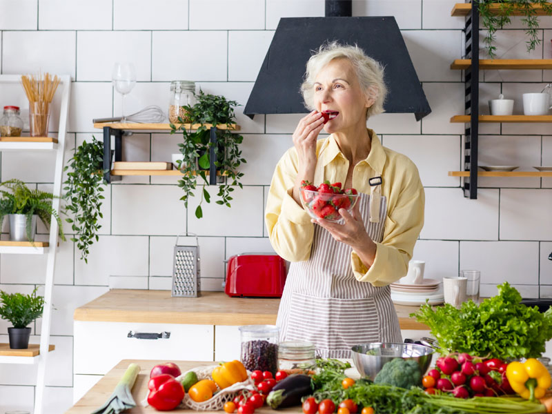 Healthy older woman eating healthy food to illustrate anti-aging strategies