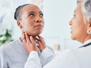 doctor examining patient's throat to illustrate healthy aging