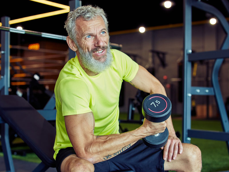 mature happy man lifting weights to illustrate testosterone replacement therapy for men