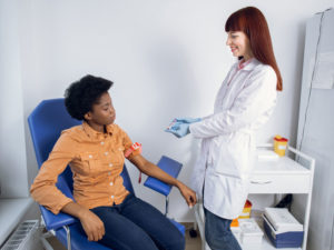 doctor taking blood to illustrate diagnosis of PCOS