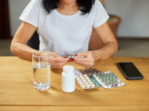 woman taking tablets to illustrate lifestyle and supplement interventions for PCOS