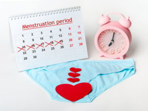 women's underwear with red hearts and menstruation diary to illustrate symptoms of PCOS