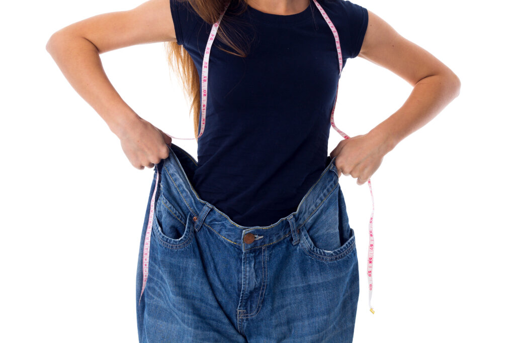 Woman wearing jeans of much bigger size due to weight loss