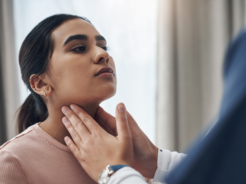 doctor feeling thyroid gland to illustrate hypothyroidism diet