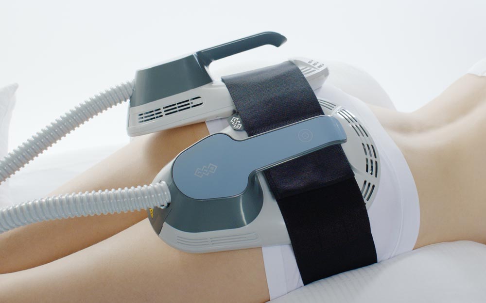 EmSculpt device attached to a woman for toning and muscle building