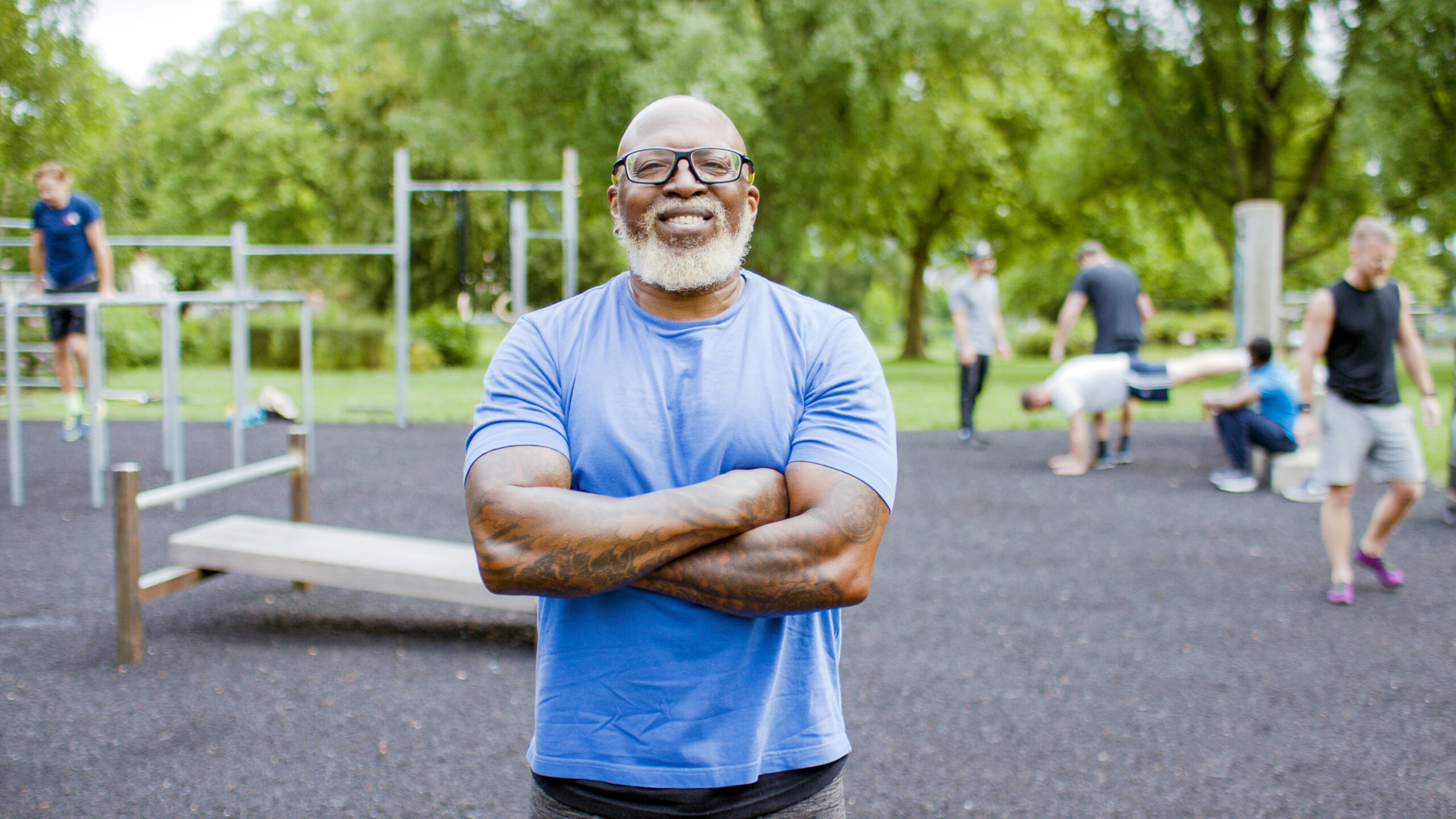 Portrait of confident, muscular black senior man with his arms folded smiling to camera