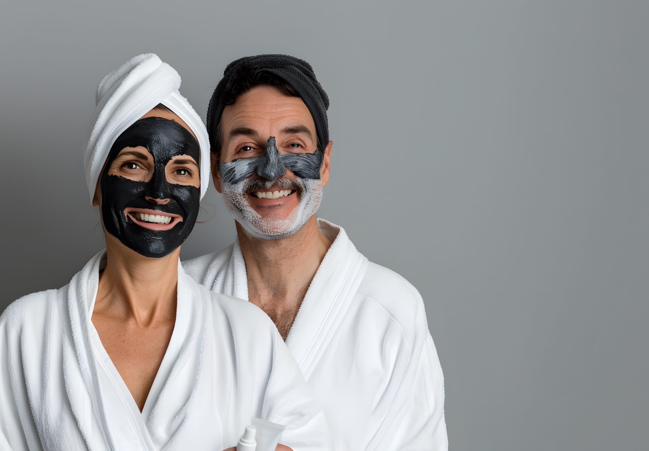 Happy Middle-Aged Couple in White Robes with Facial Masks