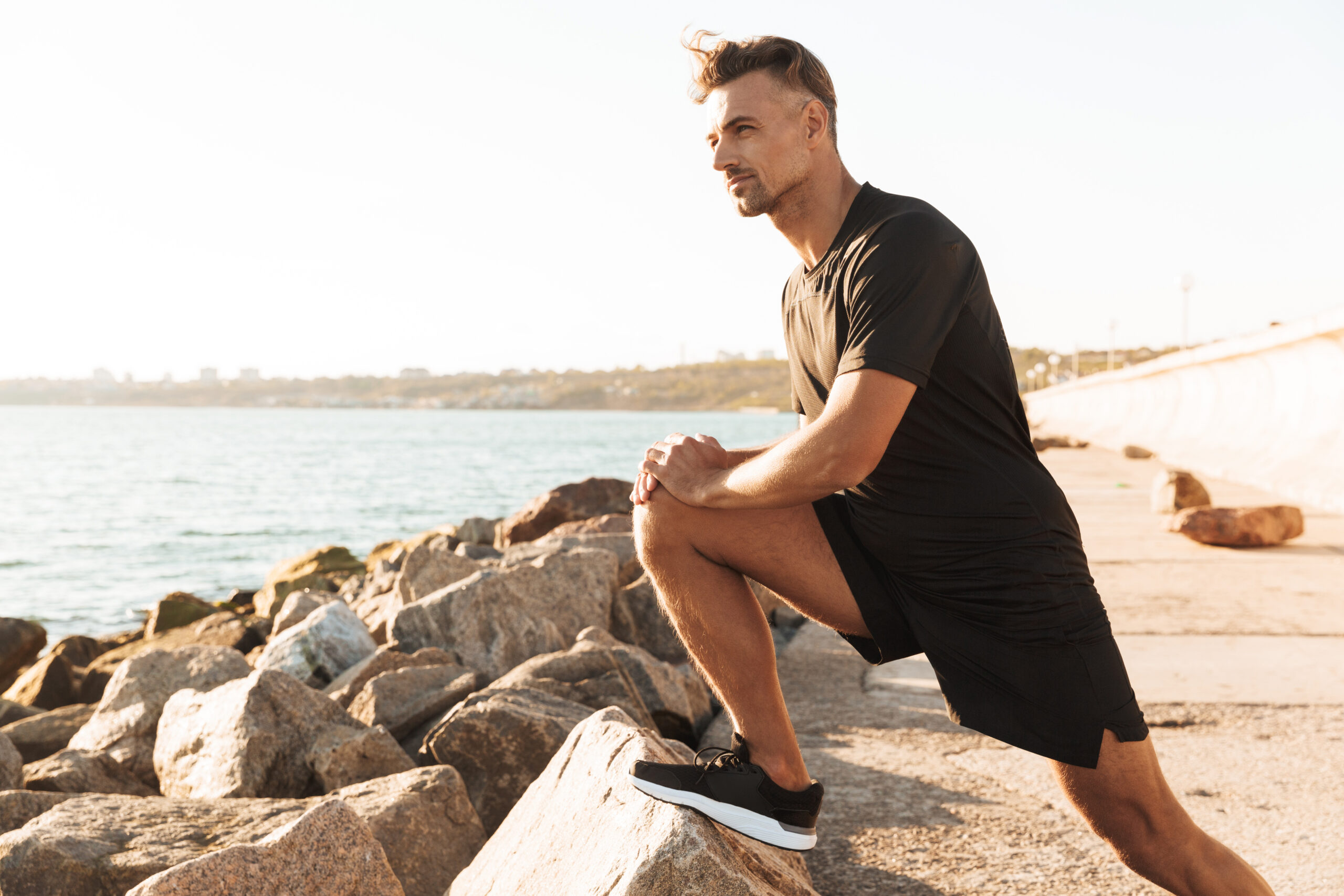 Portrait of a handsome sportsman doing stretching exercises