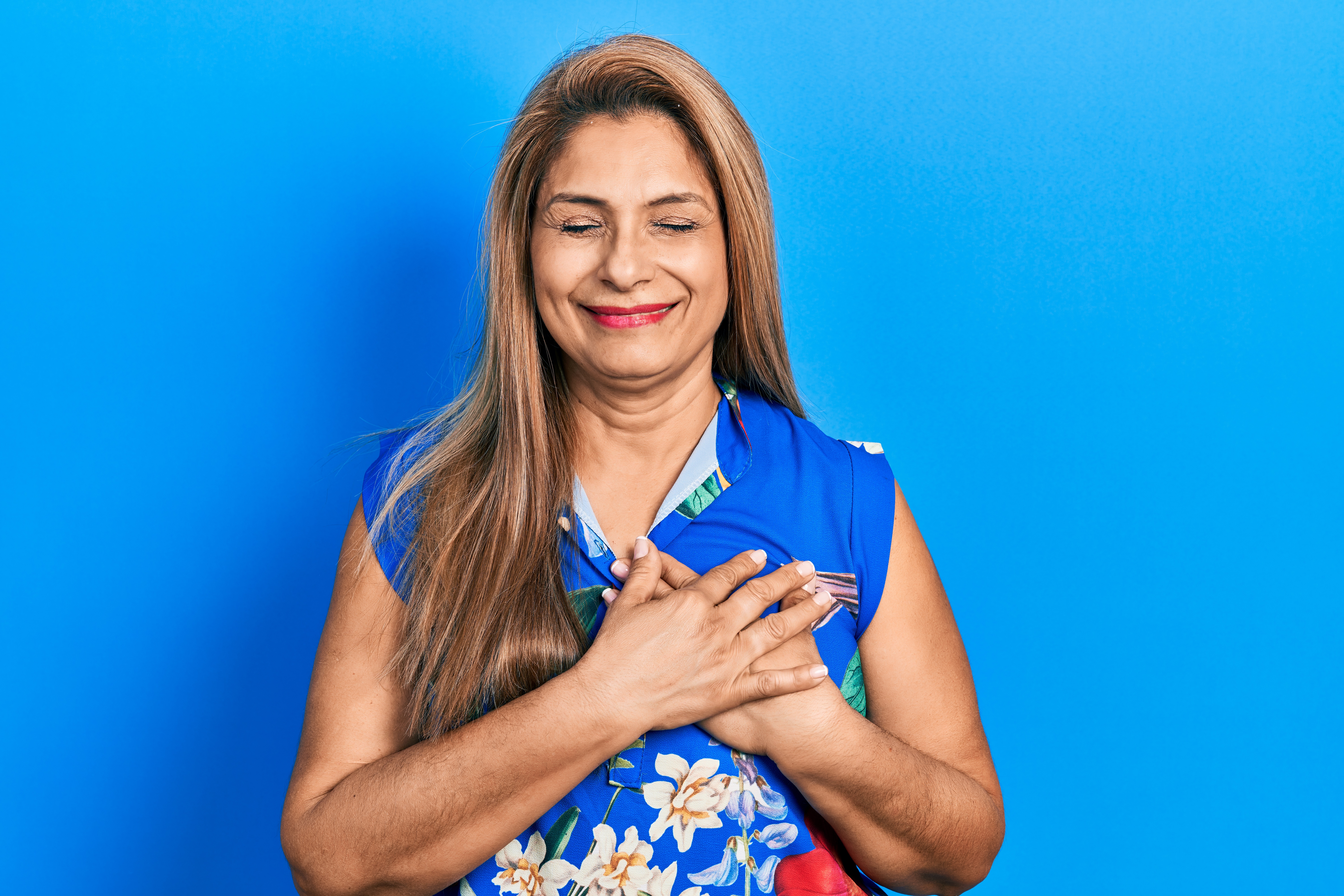 Licensed Middle age hispanic woman wearing casual clothes smiling with hands on chest with closed eyes and grateful gesture on face. health concept.